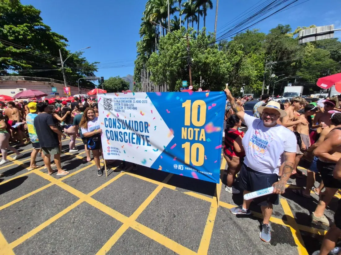 Faixa Consumidor Consciente do Procon RJ com representantes de marca em bloco de Carnaval no Rio de Janeiro