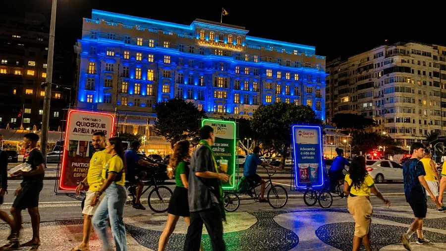 Bikeled com painéis iluminados circulando em frente ao Copacabana Palace, Rio de Janeiro